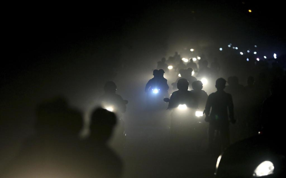 In this Friday, Nov. 10, 2017 file photo, Indian motorists ride past a thick blanket of smog and dust on the outskirts of New Delhi, India. The most recent air pollution data from the World Health Organization gives India a dubious lead. Ten Indian cities lead the list of the 20 most polluted cities in the world. (AP Photo/Altaf Qadri, File)