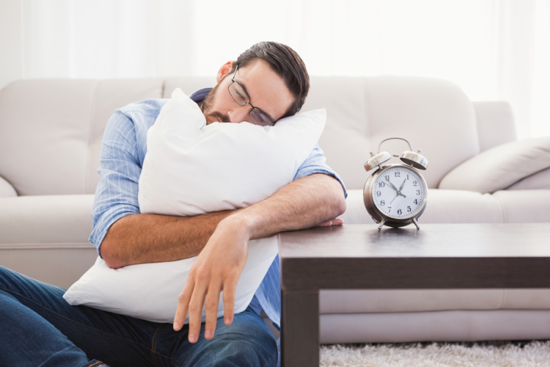 Exhausted man sleeping with head resting on pillow in the living room