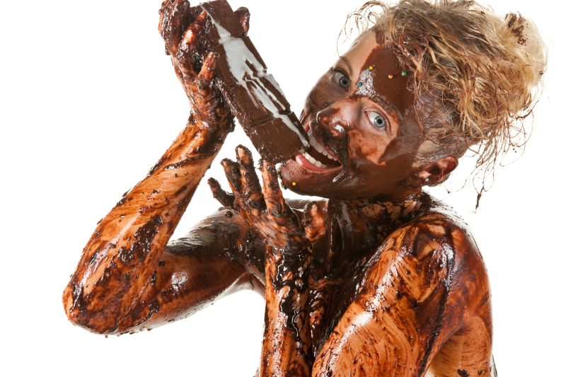 naked blond girl eating chocolate with melted chocolate all over her