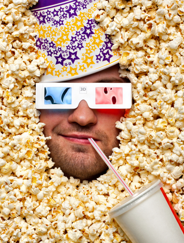 Happy face in popcorn with bucket on head watching 3D movie and drinking soda