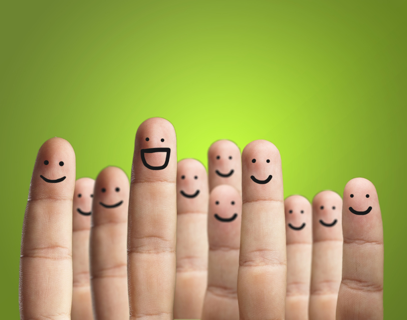 Close-up Of Fingers With Smiley Face Isolated On Green Background

