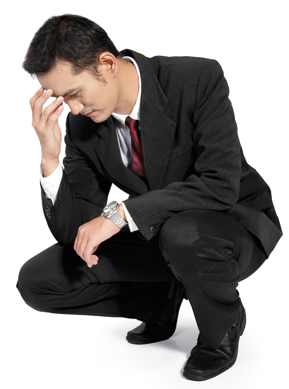Young handsome businessman feeling upset, kneel down and holding his forehead, full body isolated on white background