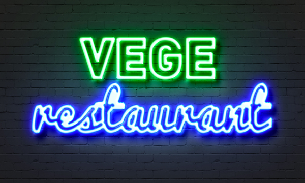Vege restaurant neon sign on brick wall background