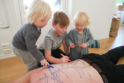 tre barn som tegner på en rygg med tusjer