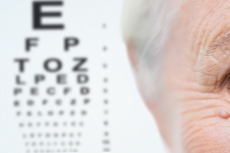 age, vision, eyesight and people concept - close up of senior woman face and eye over chart background