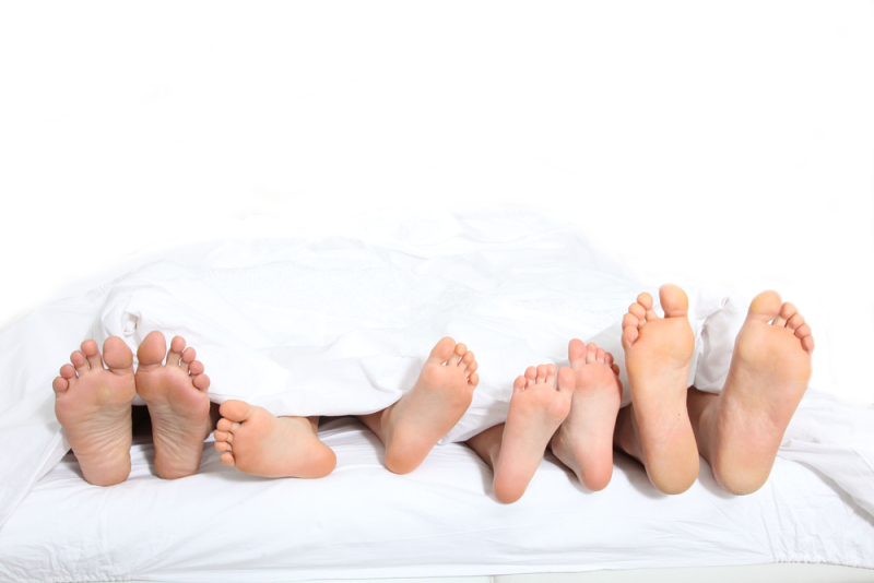 Closeup of family feet in bed