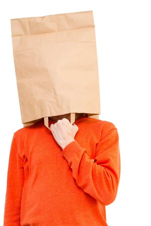 Man in paper bag on head showing with forefingers isolated on white background.