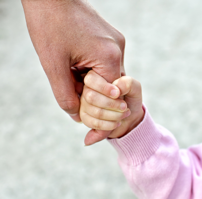 Child holding mother's hand