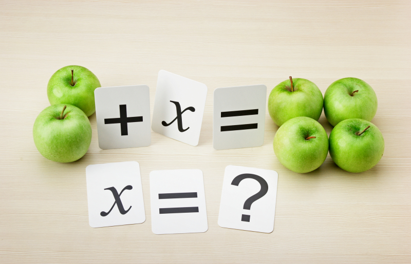 School card and apple with math problems on the table