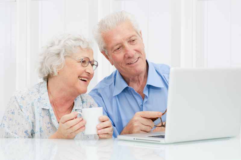 Happy elder couple enjoy together at laptop computer