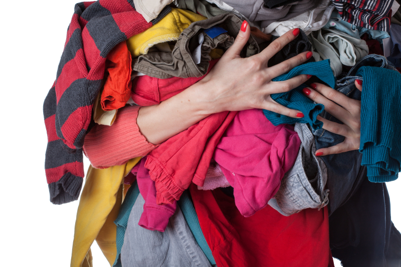 Woman holding a huge pile of clothes