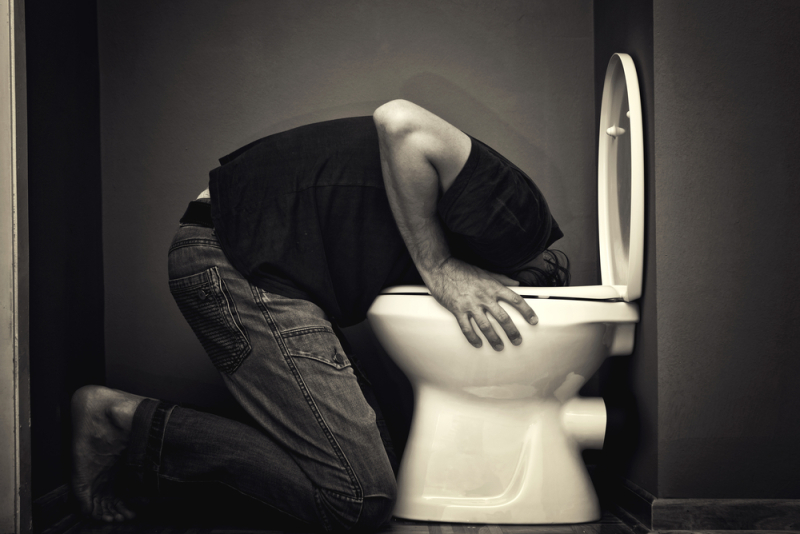 Man vomiting in toilet bowl