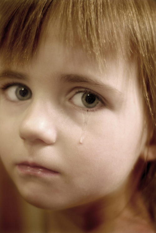 Portrait of little girl crying with tears rolling down her cheeks