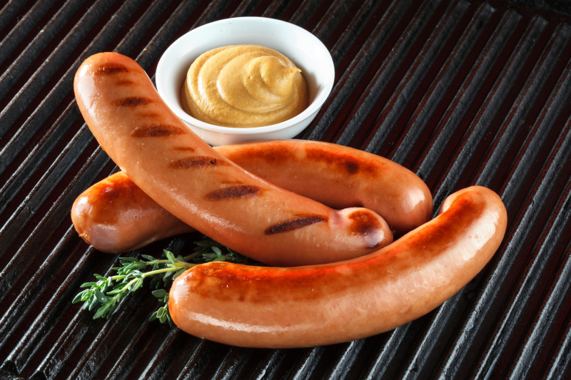 Grilled sausages on the barbecue with mustard