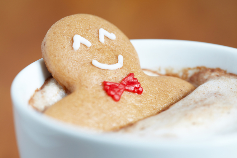 Gingerbread cookie men in a hot cup of cappuccino