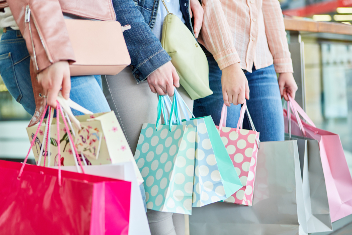 Drei Frauen mit vielen Einkaufstüten als Symbol für Konsum und Kaufkraft